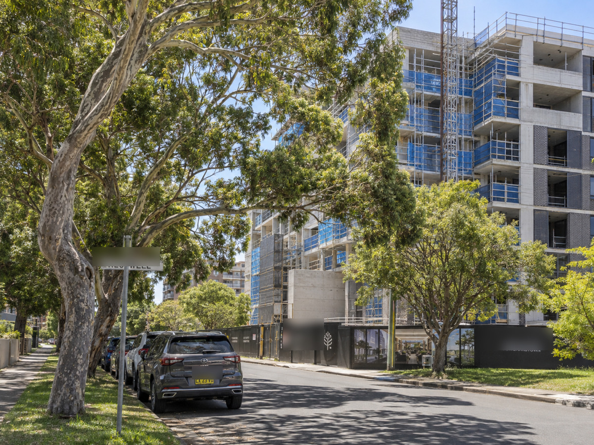 Established street trees beside a mid-rise apartment development under construction in Bankstown